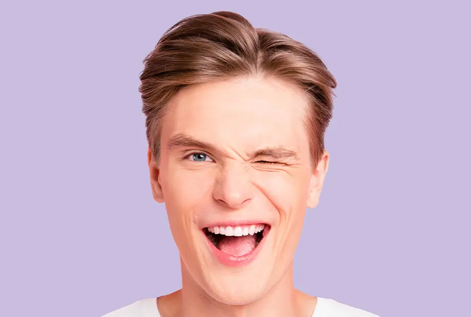 blankweiss - Patient zwinkert mit seiner Zahnschiene