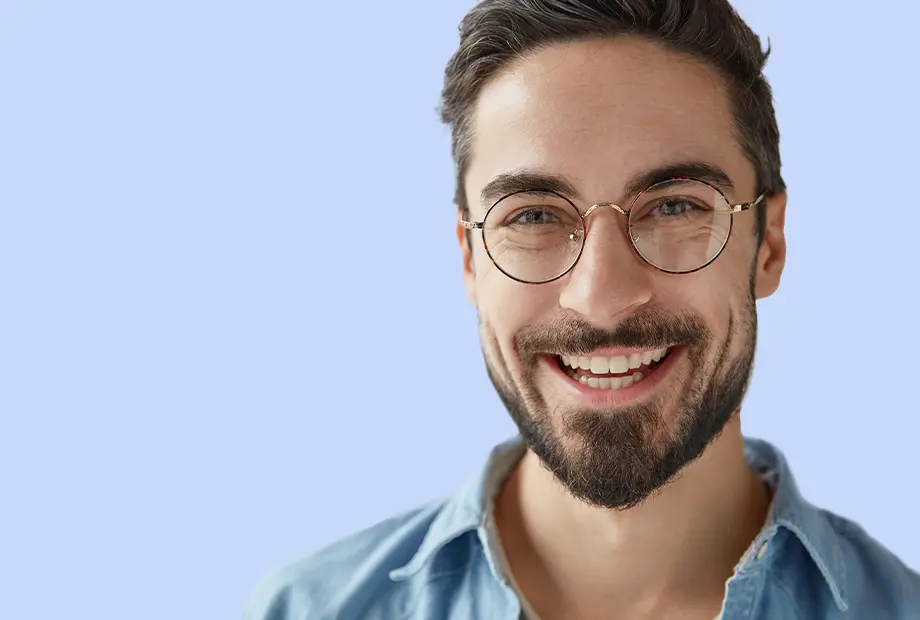 blankweiss - aestethik - Anlächelnder Patient mit Brille